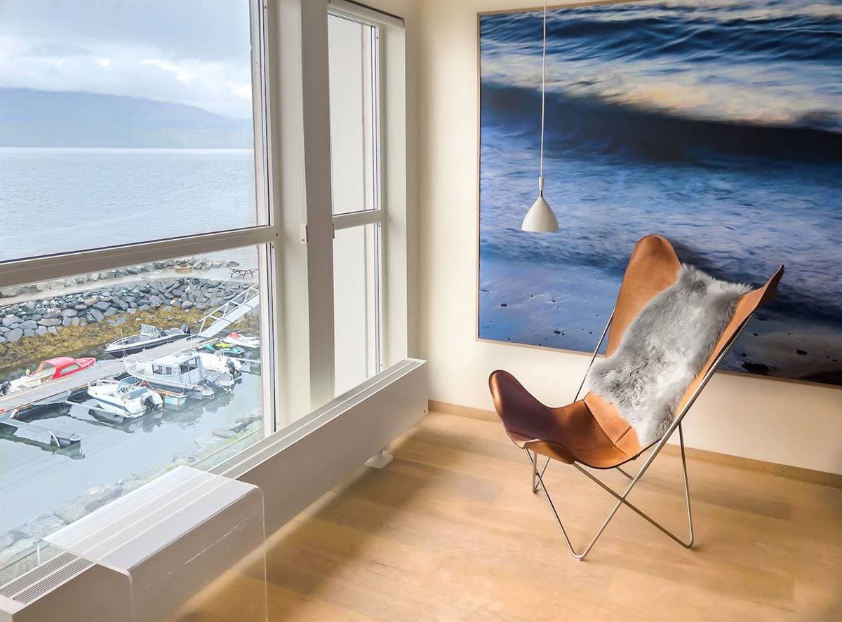Armchair in the window corner of the twin room, looking down to the marina and the fjord