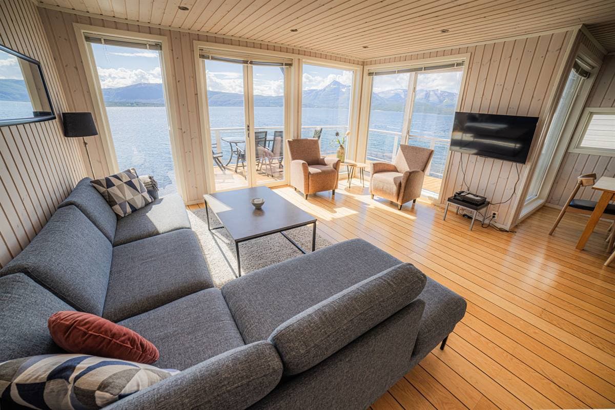 Living room with grey sofa and fjord view