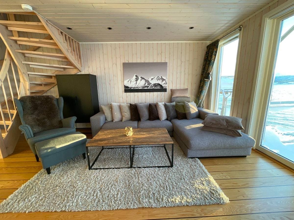 Living room with sofa, staircase and fjord view