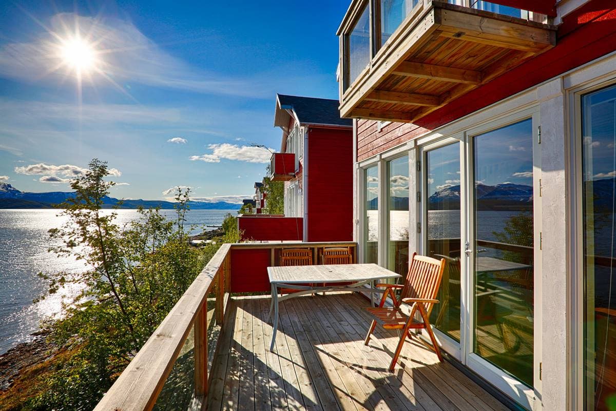 Balcony with table and chairs above the fjord