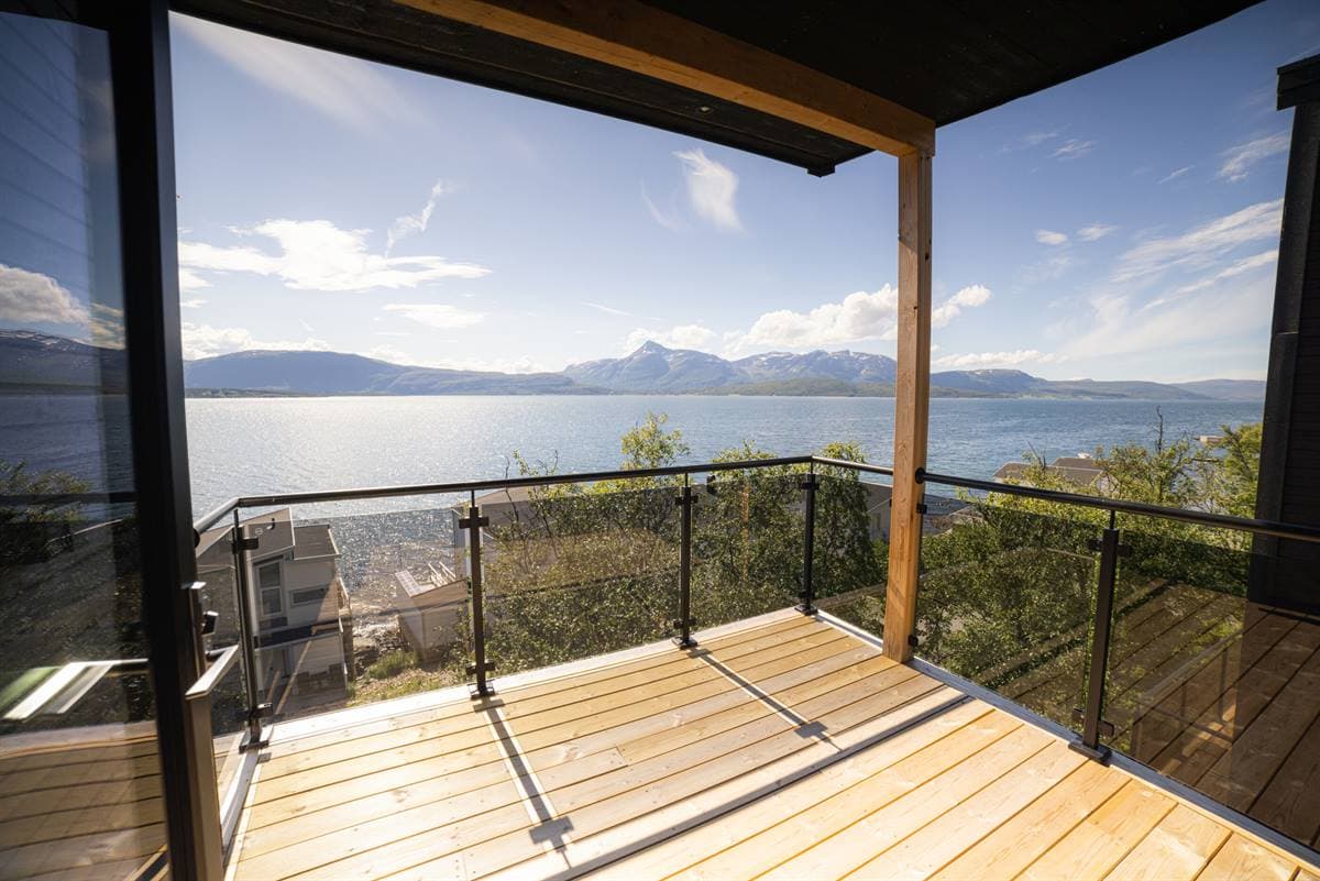 Balcony with glass railing above the fjord