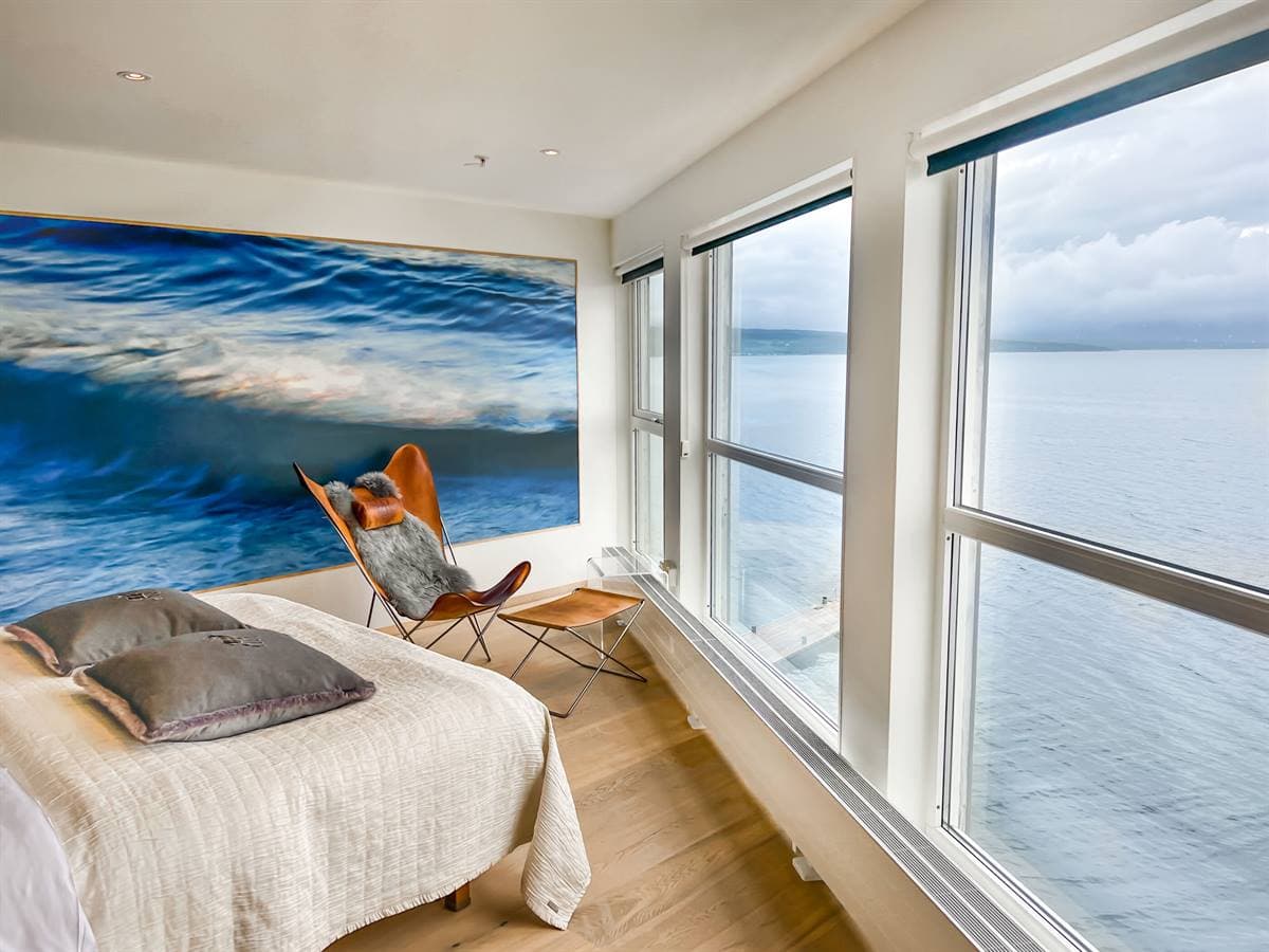 Double bed, butterfly chair and an ocean-wave mural in the Junior Suite