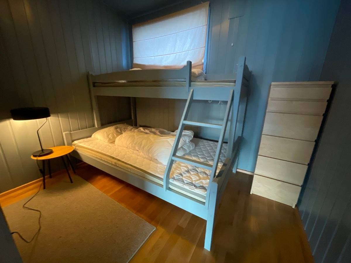 Bedroom with a bunk bed that has a wider lower bunk