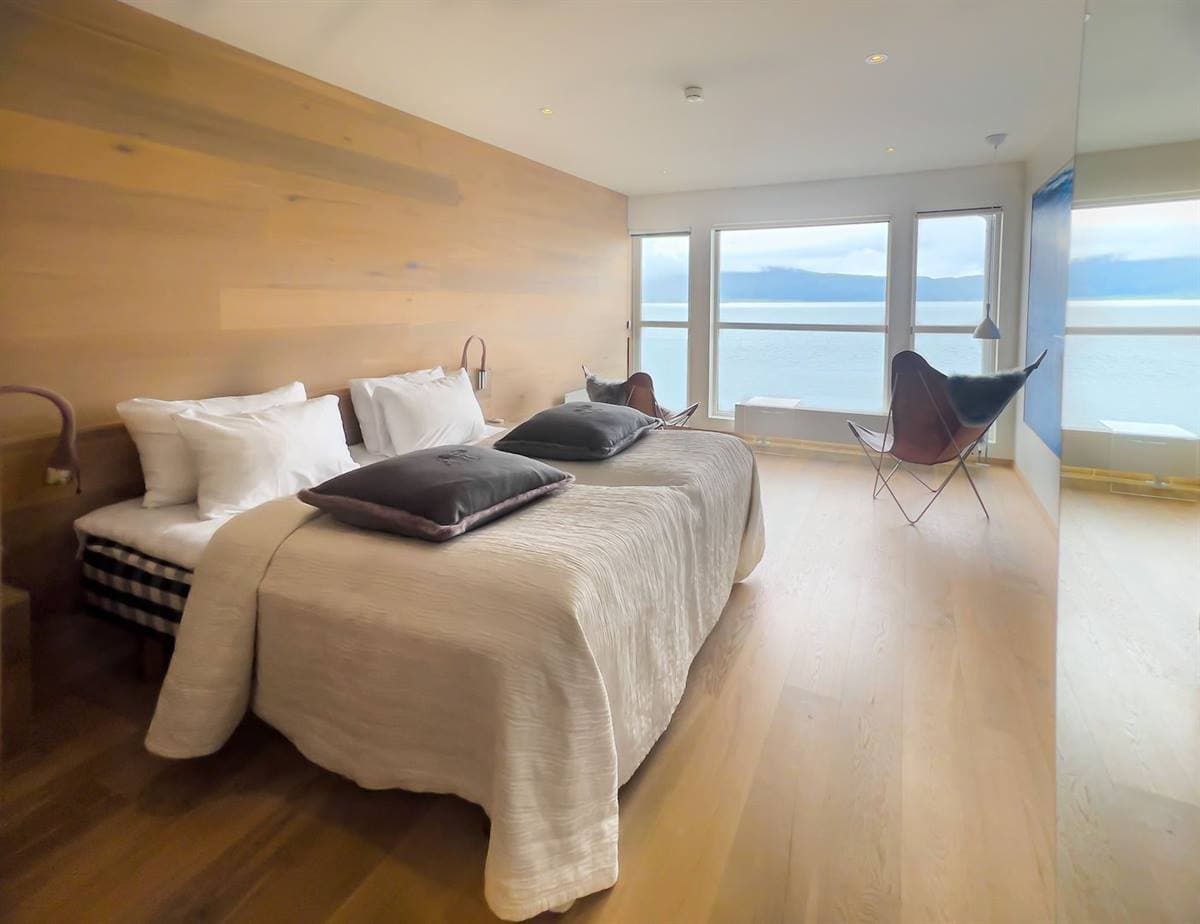 Twin room with two beds side by side, an oak-panelled wall and windows facing the fjord